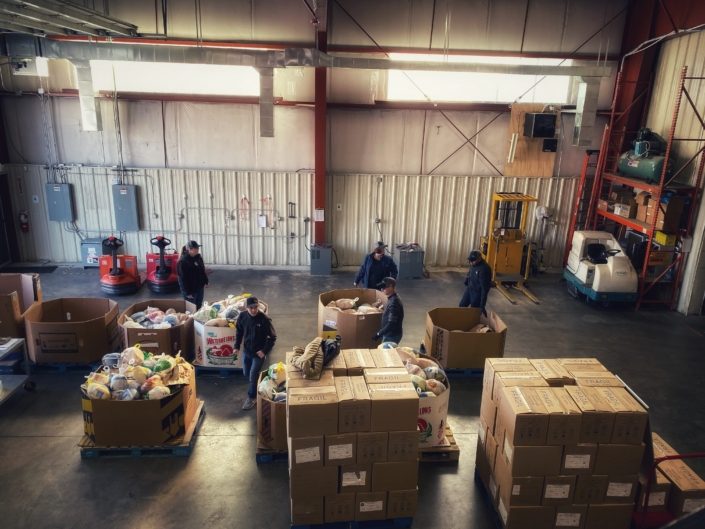 Produce & Groceries Inside of A Warehouse With Warehouse Workers